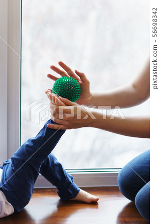 Mother makes foot massage to child. Mother makes foot massage to child. 56698342