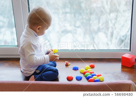 Child is building constructor on windowsill. 56698480