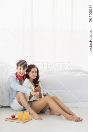 Asian couple sitting on the floor in the bedroom.. 56700085