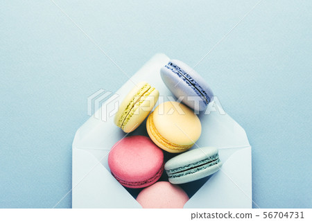 Colorful macarons in envelope on blue background. 56704731