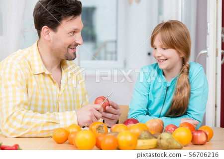 Father cutting apple with knife for his daughter Father cutting apple with knife for his daughter 56706216