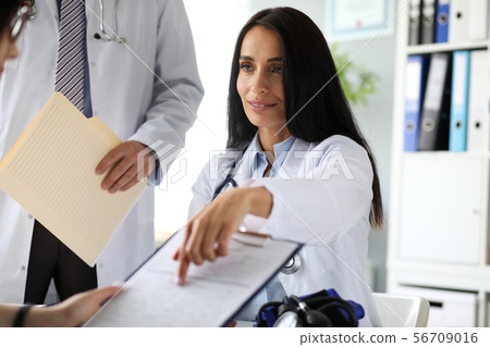 Beautiful caucasian female GP pointing finger in application form Beautiful caucasian female GP pointing finger in application form 56709016