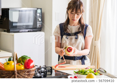 Mother cooking with baby Mother cooking with baby 56709410