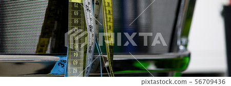 Measuring ribbons hanging on a black chair 56709436