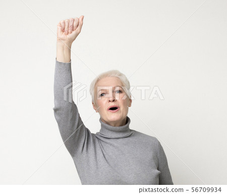 Confident mature woman with her fist up in the air. 56709934