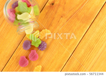colored gummy fruit candy spilled, on a orange 56711344