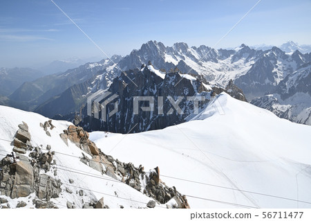 Climbers go up the ridge against the backdrop of Aiguille Belt and Les Droite Climbers go up the ridge against the backdrop of Aiguille Belt and Les Droite 56711477