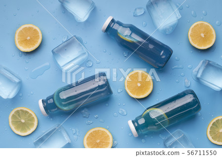 Summer background with blue detox water, fresh lemons and ice Summer background with blue detox water, fresh lemons and ice 56711550