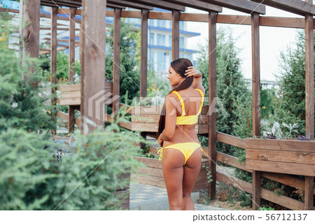 beautiful woman with long hair on the beach stands back 56712137