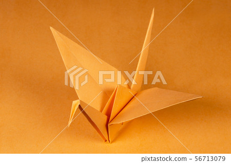 Orange origami crane tsuru on orange background Orange origami crane tsuru on orange background 56713079