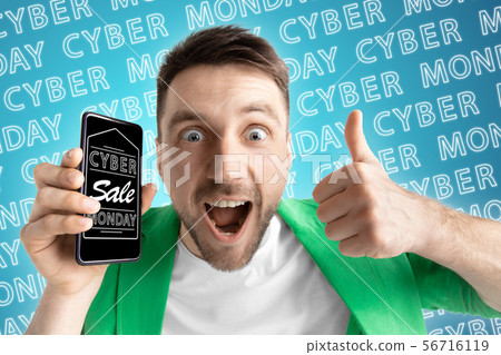 Portrait of man showing screen of mobile phone, black friday 56716119