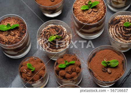 Group of portions of Classic tiramisu dessert in a glass cup on stone board on concrete background Group of portions of Classic tiramisu dessert in a glass cup on stone board on concrete background 56716687