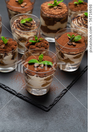 Group of portions of Classic tiramisu dessert in a glass cup on stone board on concrete background Group of portions of Classic tiramisu dessert in a glass cup on stone board on concrete background 56716698