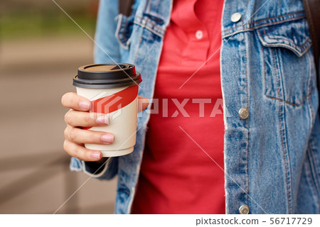 Woman hand with paper cup of coffee take away Woman hand with paper cup of coffee take away 56717729