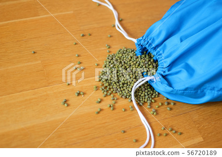 Green mung bean in blue reusable package on wooden background. Eco packaging concept Green mung bean in blue reusable package on wooden background. Eco packaging concept 56720189