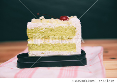 Green cake slice with cherry fruit and cream on 56721246