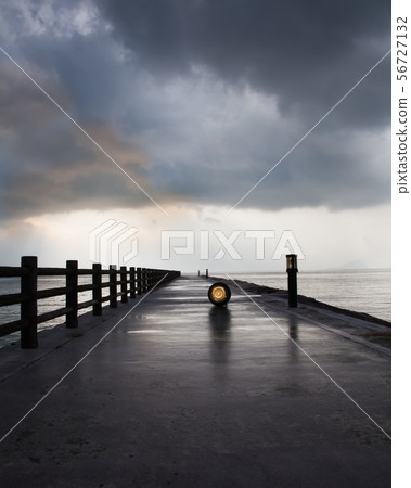 It is a pier on Suo-Oshima. A quiet early morning landscape after the rain. Part of the rain cloud is red. 56727132