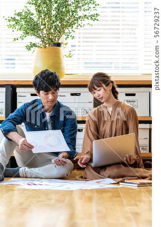 Man and woman sitting on the office floor Man and woman sitting on the office floor 56729237