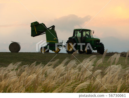 It is the dusk scenery of Aso ranch. We manage hay with farm trucks. It is the dusk scenery of Aso ranch. We manage hay with farm trucks. 56730061
