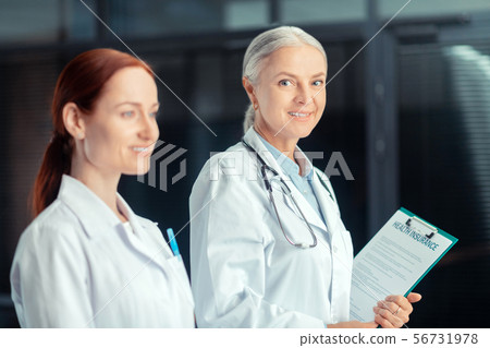 Smiling female doctor with a medical insurance certificate 56731978