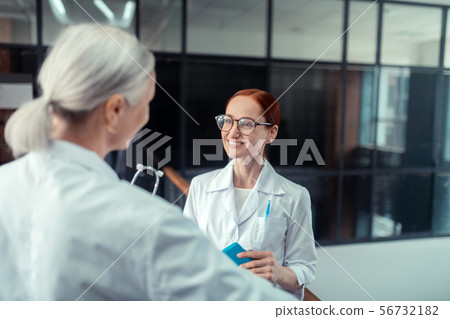 Good-looking red-haired young female doctor in eyeglasses 56732182