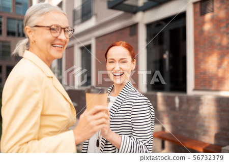 Women laughing in front of an office building 56732379