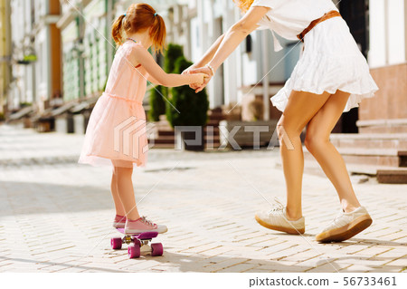 Active little girl going skateboarding with mom 56733461