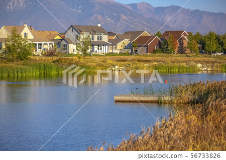 Wooden deck on lake with homes and mountain view 56733826
