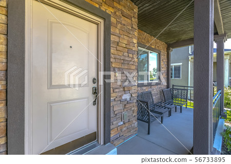 White front door of home with furniture on porch White front door of home with furniture on porch 56733895