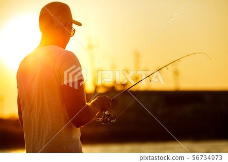 Young man fishing at sea Young man fishing at sea 56734973