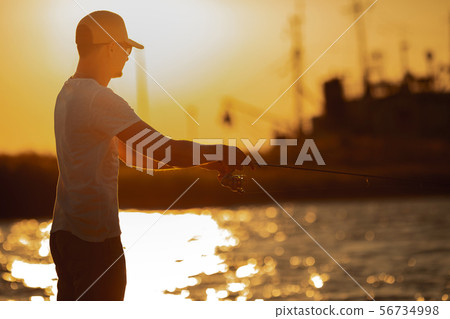 Young man fishing at sea 56734998