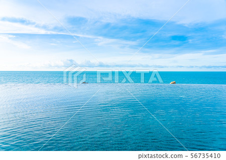 Beautiful outdoor infinity swimming pool in hotel resort with sea ocean view and white cloud blue sky Beautiful outdoor infinity swimming pool in hotel resort with sea ocean view and white cloud blue sky 56735410