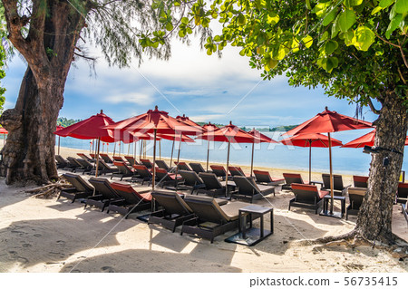 Beautiful outdoor tropical beach sea ocean with umbrella chair and lounge deck around there on white cloud blue sky Beautiful outdoor tropical beach sea ocean with umbrella chair and lounge deck around there on white cloud blue sky 56735415