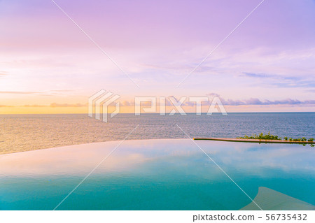 Beautiful outdoor infinity swimming pool in hotel resort with sea ocean view and white cloud blue sky Beautiful outdoor infinity swimming pool in hotel resort with sea ocean view and white cloud blue sky 56735432