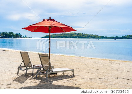Beautiful outdoor tropical beach sea ocean with umbrella chair and lounge deck around there on white cloud blue sky Beautiful outdoor tropical beach sea ocean with umbrella chair and lounge deck around there on white cloud blue sky 56735435