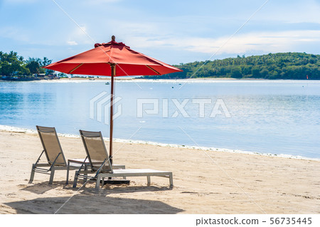Beautiful outdoor tropical beach sea ocean with umbrella chair and lounge deck around there on white cloud blue sky Beautiful outdoor tropical beach sea ocean with umbrella chair and lounge deck around there on white cloud blue sky 56735445