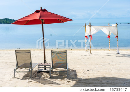 Beautiful outdoor tropical beach sea ocean with umbrella chair and lounge deck around there on white cloud blue sky Beautiful outdoor tropical beach sea ocean with umbrella chair and lounge deck around there on white cloud blue sky 56735447