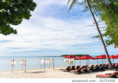 Beautiful outdoor tropical beach sea ocean with umbrella chair and lounge deck around there on white cloud blue sky 56735488