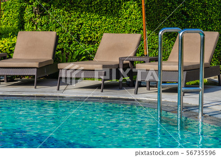 Beautiful umbrella and chair around outdoor swimming pool in hotel resort for holiday vacation travel Beautiful umbrella and chair around outdoor swimming pool in hotel resort for holiday vacation travel 56735596