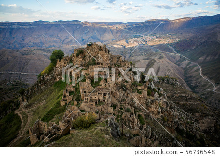 Photo of ancient ruins of mountain area with green vegetation against cloudy blue sky 56736548