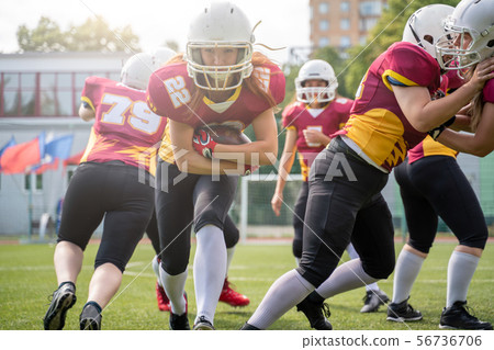 Full-length image of athletes women playing american football on green lawn on summer day Full-length image of athletes women playing american football on green lawn on summer day 56736706