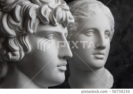 Gypsum copy of ancient statue Antinous and Venus head on dark textured background. Plaster sculpture Gypsum copy of ancient statue Antinous and Venus head on dark textured background. Plaster sculpture 56738150