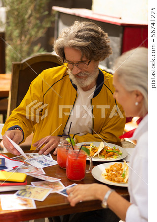 Concentrated man looking with his wife at photographs. Concentrated man looking with his wife at photographs. 56741225