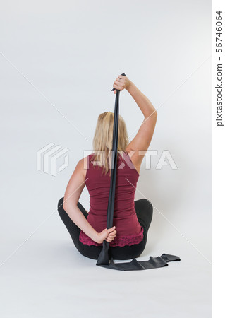 Rear view of a young woman stretching back with a Rear view of a young woman stretching back with a 56746064