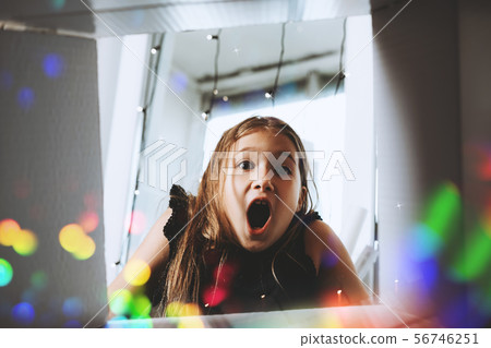 Happy girl opening present Happy girl opening present 56746251