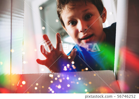 Happy boy unwrapping present 56746252