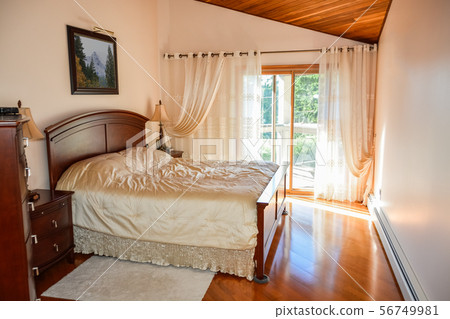 Beautiful bedroom with sun light coming through glass door. 56749981