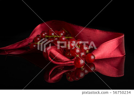 Fresh red currant isolated on black glass Fresh red currant isolated on black glass 56750234