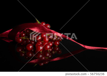 Fresh red currant isolated on black glass Fresh red currant isolated on black glass 56750236