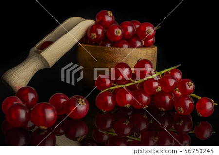 Fresh red currant isolated on black glass Fresh red currant isolated on black glass 56750245